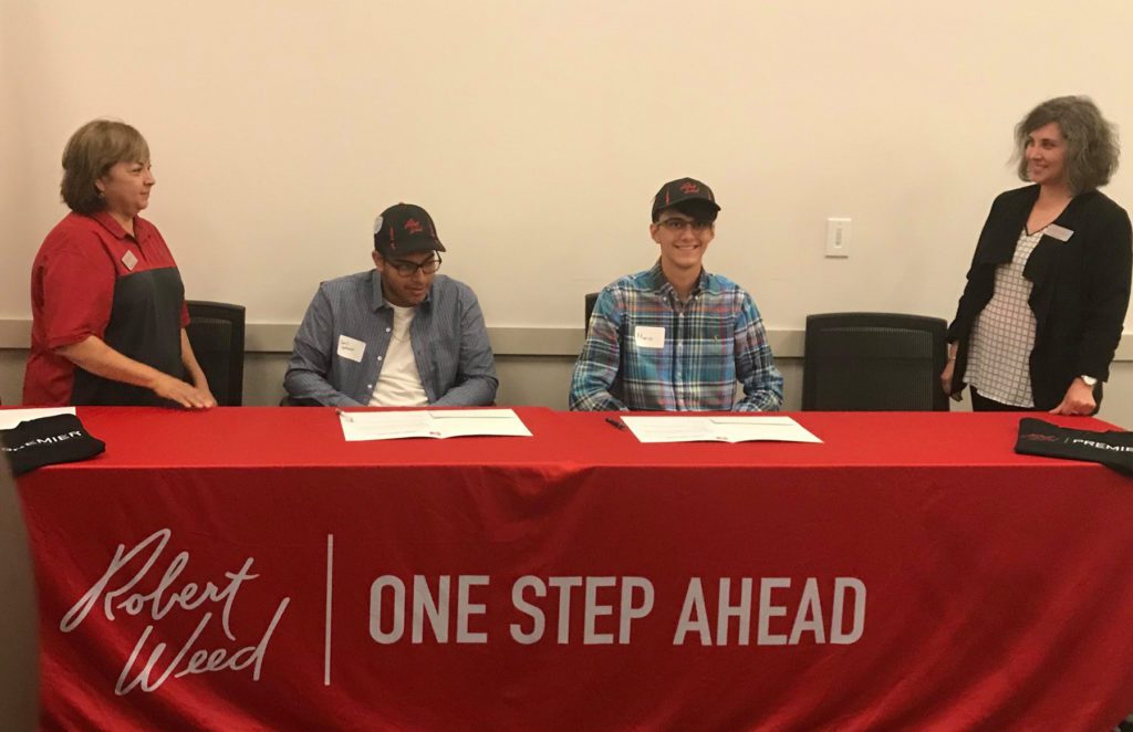 Mario Garcia (right, sitting) signs his letter of intent to become a youth apprentice at Robert Weed Corporation in Elkhart in 2019.